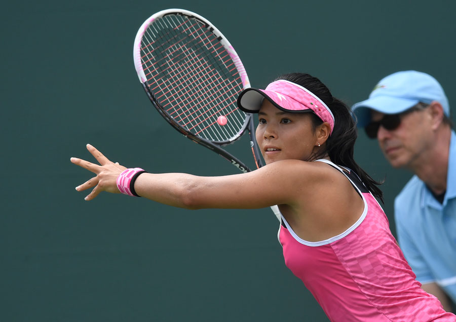 Tennis spielende Frau in pinkem Outfit